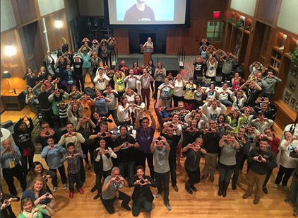 Image: DMAIG Members at an event in the Hintz Alumni center holding up their hands in diamond shape